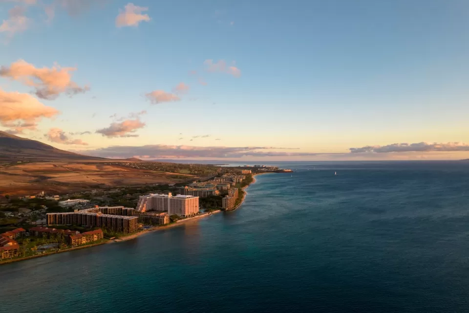 Aerial view of coast in Maui, hawaii with hotels and condo buildings at sunrise or sunset.